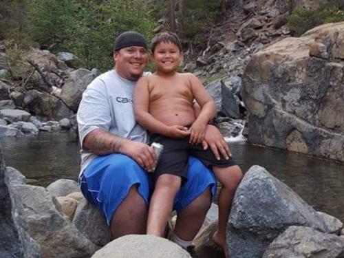Colby relaxing outdoors with his son